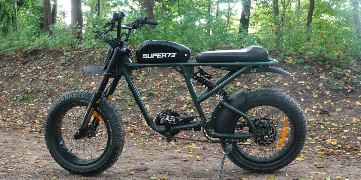 a motorcycle parked next to a forest