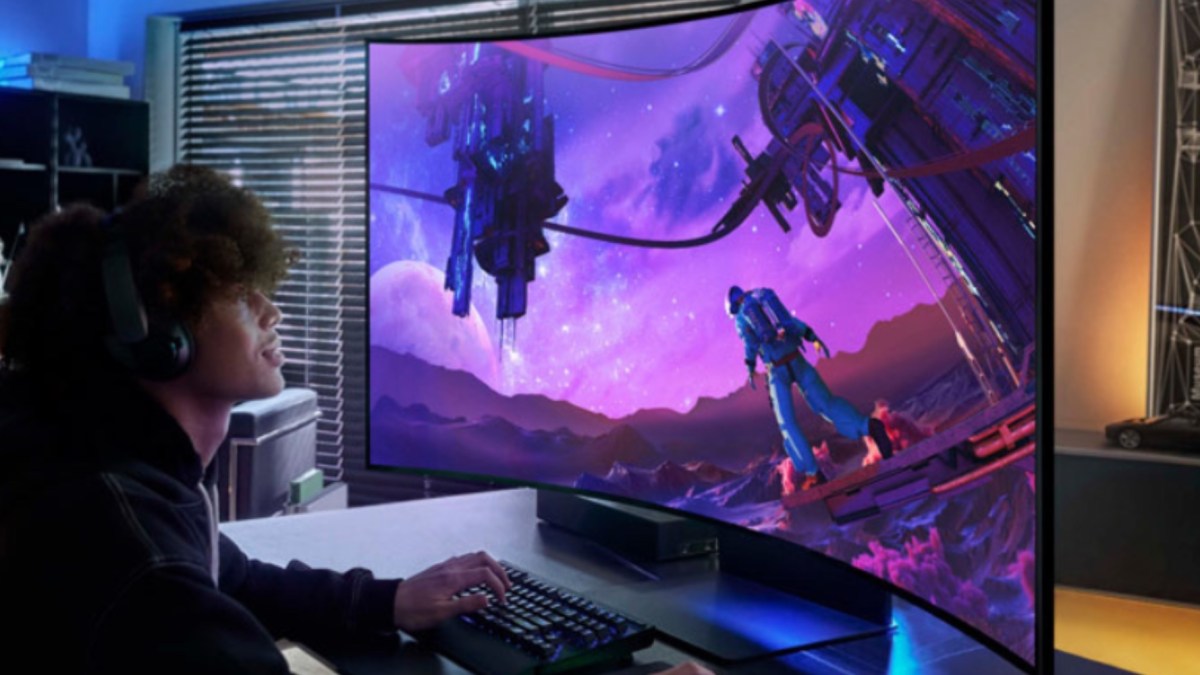 a man sitting at a desk with a laptop computer monitor and keyboard