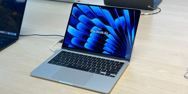 an open laptop computer sitting on top of a wooden table