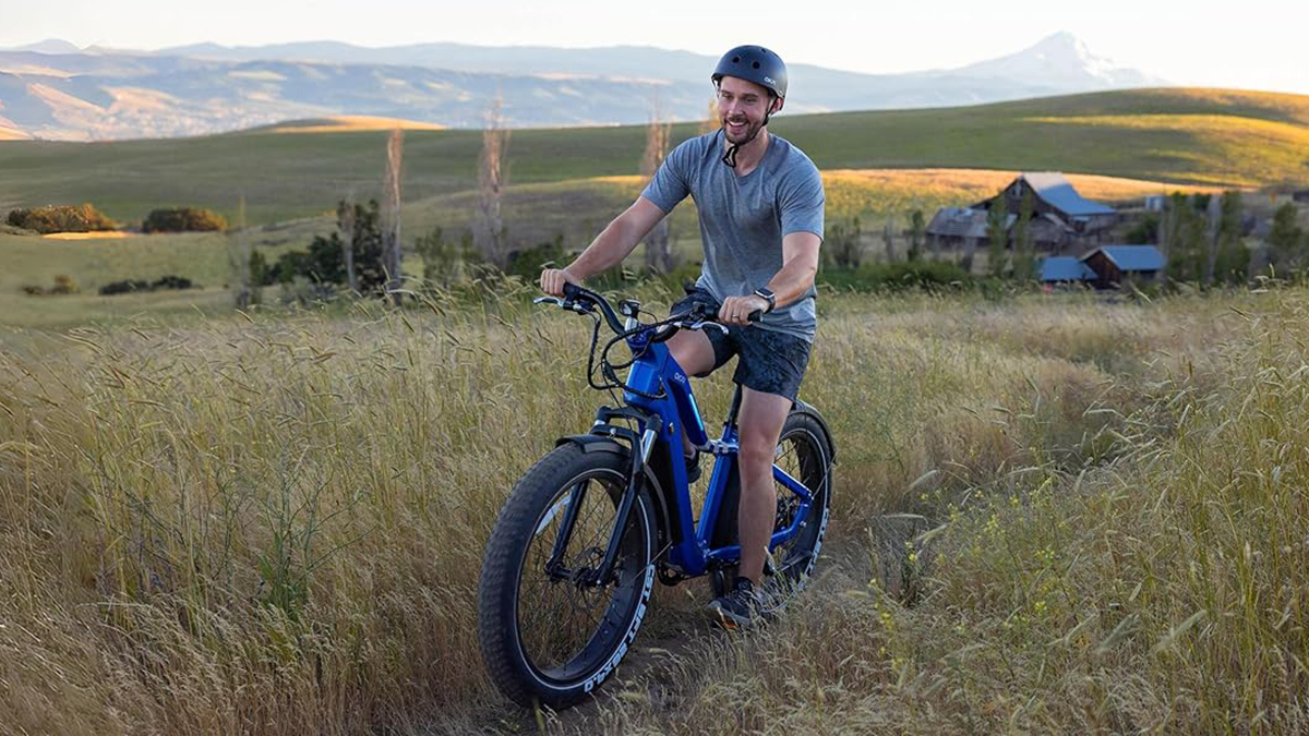 a man riding a bike down a dirt road