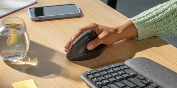 a person sitting at a desk in front of a keyboard