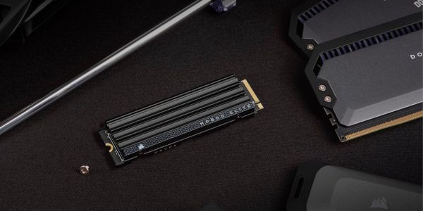 Corsair MP600 Elite SSD on a desk next to RAM modules.