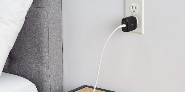 Image showing Amazon's 30W USB-C wall charger powering a device on a bedside table.